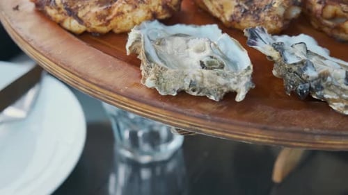 Woman Hand Take Raw Oyster From Seafood Wooden Plate Close Up of Charcuterie Platter Board with