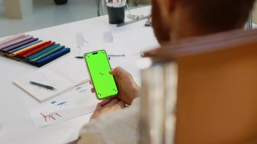 Man Holding Smartphone with Chroma Key Screen in Studio