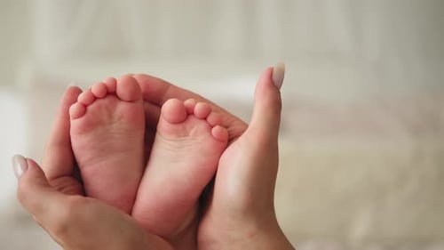 Delicate Baby Feet Held with Love