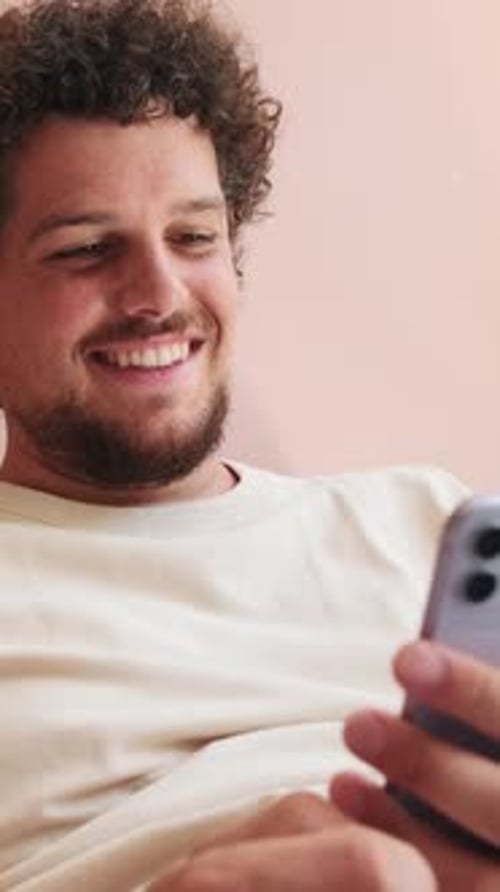 Man Smiling While Using Mobile Phone