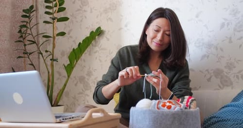 Woman Crocheting with Yarn at Home