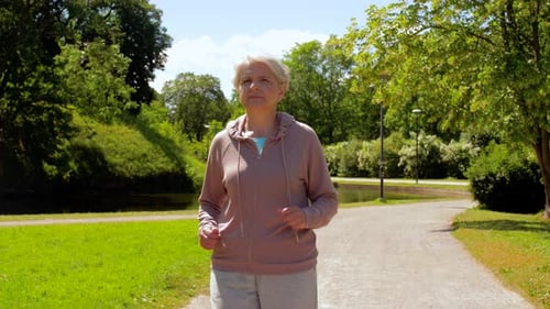 Senior Woman Jogging on Sunny Park Path