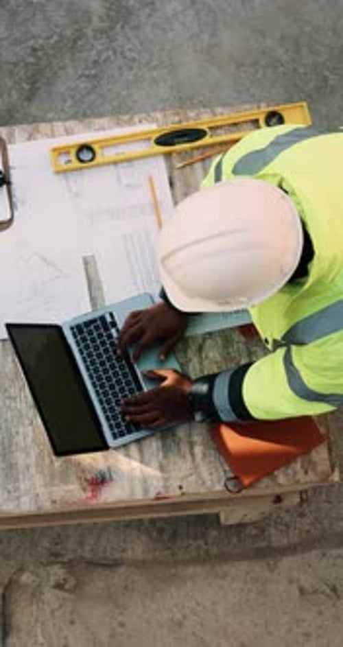 Blueprint, drawing and construction worker with laptop on site for planning home renovation
