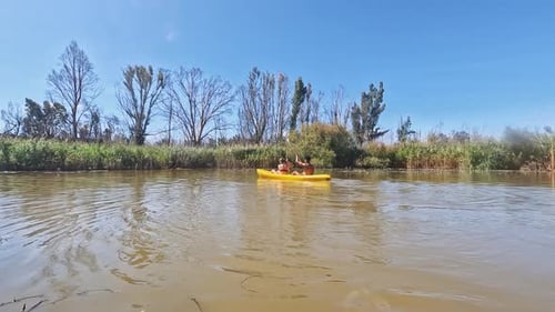 Boat, canoe and friends on river in nature for holiday, summer vacation and weekend outdoors