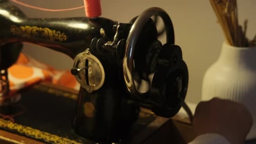 Close-up of a woman's hand sewing on a sewing machine