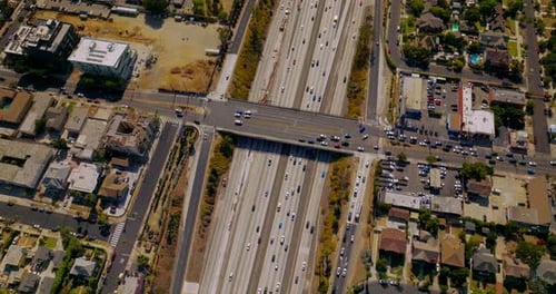 Road bridge over the wide multi-lane motorway with busy traffic.