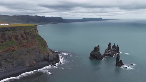 Aerial View of Icelandic Cliffside with Black Sand Beach and Waves