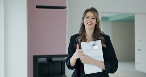 With a Beaming Smile the Blonde Real Estate Agent Confidently Holds the Contract Plan of the House