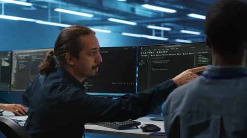 Men Coding Together in High Tech Server Hub Using Computers to Analyze Data