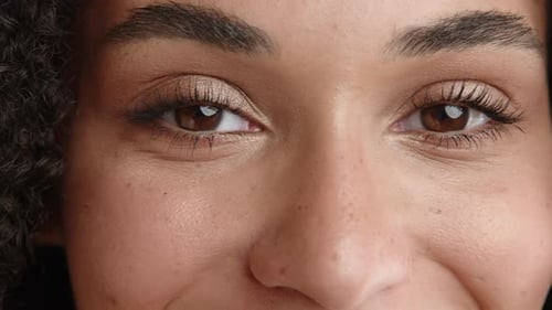 Close Up of Beautiful Hazel Eyes of Pretty Woman of Mixed Race Winking Smiling