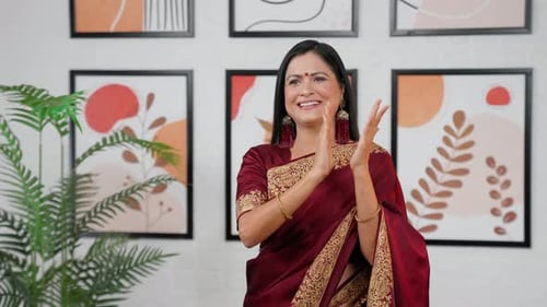 Smiling Woman in Sari Clapping Hands Indoors