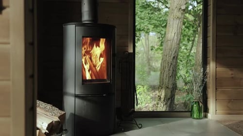 Modern Fireplace Burning Logs Inside Wood Paneled Home