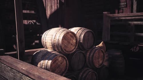 Stack of Wooden Barrels in a Rustic Warehouse During the Afternoon Light
