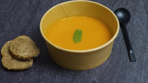 Close Up of Orange Soup in Bowl With Bread