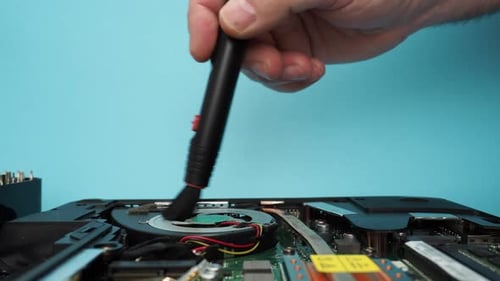 Der Meister repariert einen kaputten Laptop mit einem Schraubenzieher.
