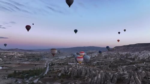 Hot Air Balloons Floating Over Rocky Valley at Sunrise