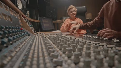 Musicians Working on Mixing Board at Sound Studio