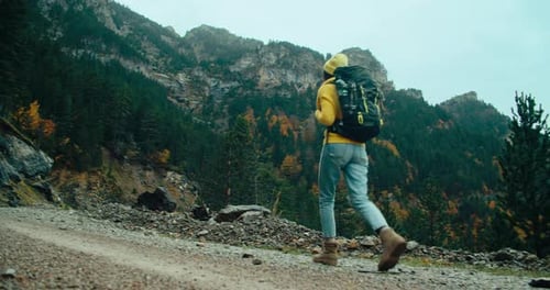 Hiker Tourist Walk on Mountain Road with Backpack on Autumn Vacation Travel