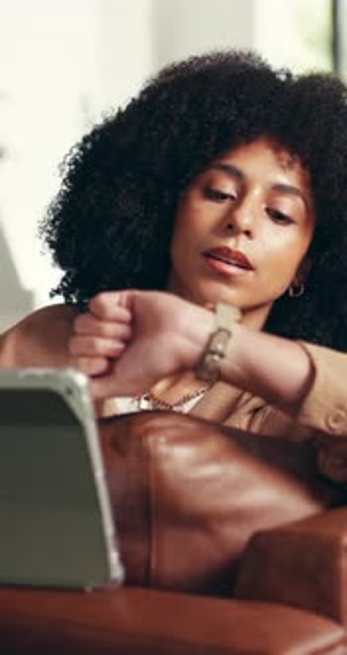 Woman Relaxes Checking Smartwatch While Sitting on Couch