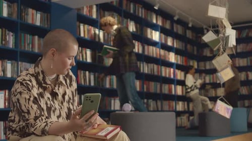 Young Woman Having Video Call on Smartphone in Public Library