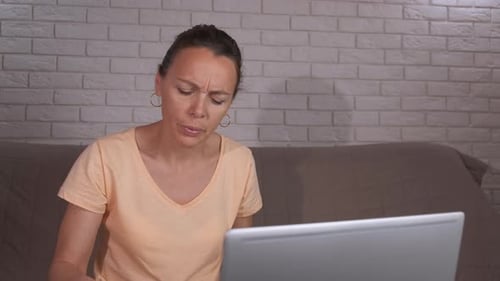 Woman Looking Stressed While Working On Laptop