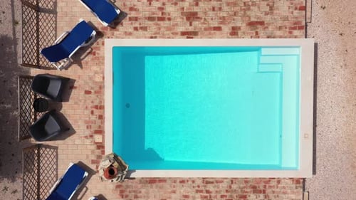 Top View of an Empty Swimming Pool with Lounge Chairs for Relaxation