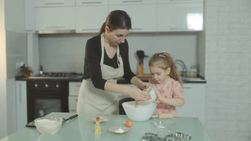 Mother and Daughter Baking Together in Kitchen