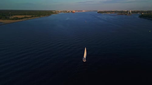Aerial View of a Sailboat on a River at Sunset Highlighting the Beauty and Tranquility of the Scene
