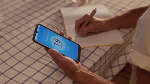 Senior Man Checks Blood Sugar with Smartphone