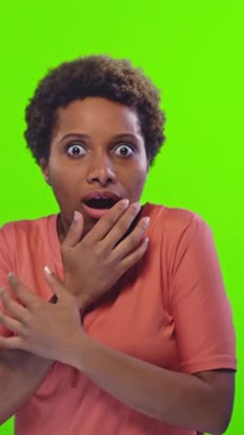 Une personne surprise réagit sur un fond vert vif dans un studio