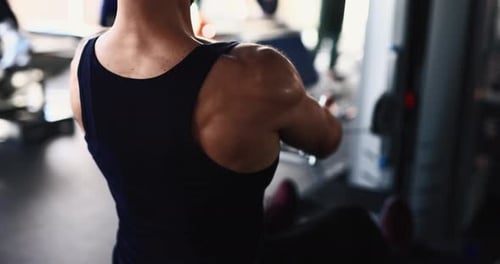 Man Exercising at Gym on Training Apparatus