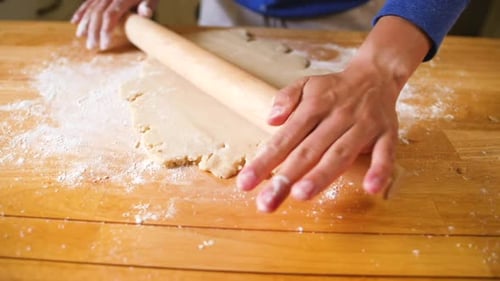 Dough Being Rolled on a Wooden Table