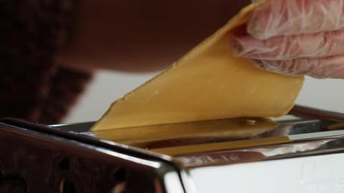 Woman Using Pasta Machine to Make Fresh Pasta Dough in the Kitchen Cooking in Italian Restaurant