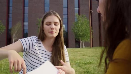 Zwei kaukasische Studentinnen, die außerhalb des Universitätscampus studieren. Aufgenommen mit RED-Heliumkamera
in