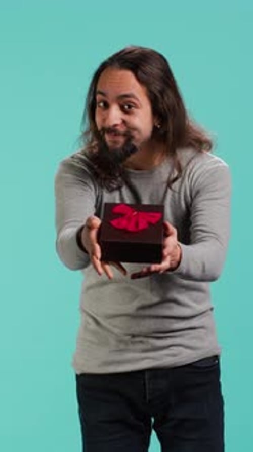 Vertical Video Portrait of Smiling Man Offering Gift for Birthday Celebration