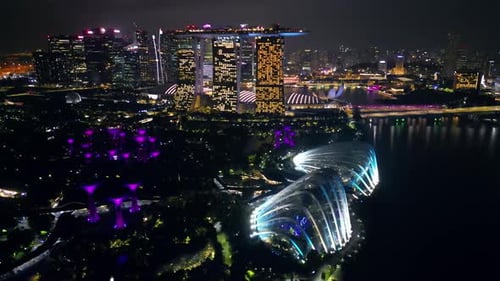 Aerial drone view of Marina Bay in Singapore at night showing Marina Bay Sands, the Singapore Flyer