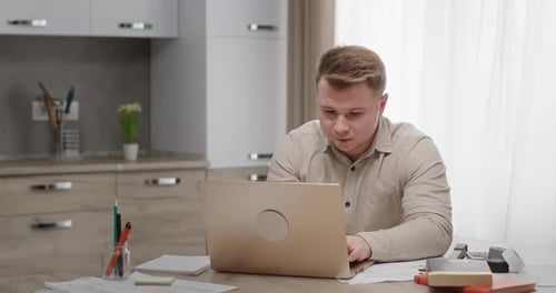 Young Adult Working on Laptop at Home