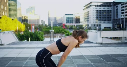 An attractive young woman checking the time while out jogging in the city