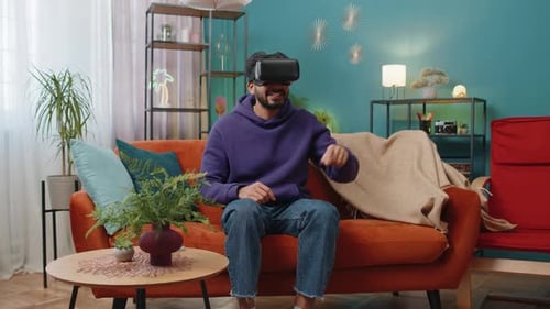 Young Man Enjoys Virtual Reality Experience At Home