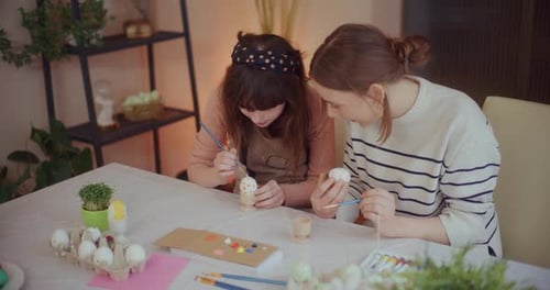 Mother and Daughter are Painting Easter Eggs for Easter Holidays