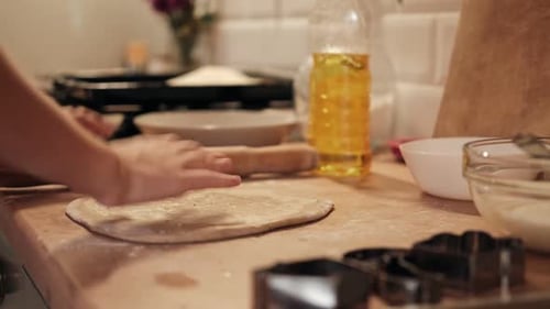 Children Rolling Out Cookie Dough with Wooden Rolling Pin on the Kitchen Countertop Kids Baking