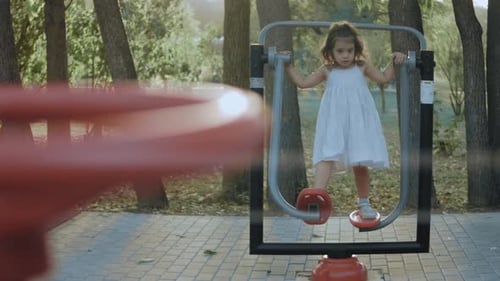 Child Exercising on Equipment Outdoors in Daytime
