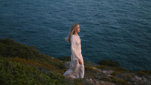 Thoughtful Woman Walking Ocean Cliff Alone. Dreaming Girl Stepping Marine View Hill at Summer Eve...