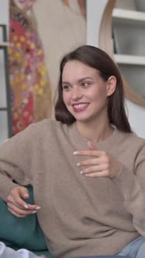 Couple heureux ayant une conversation assis sur un canapé, Vidéo verticale