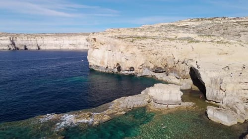 Drone aerial view of the Dwejra cliffs in Gozo, Malta, cinematic 60FPS footage showcasing dramatic