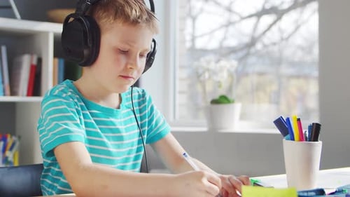 Focused Boy Learning at Desk with Headphones