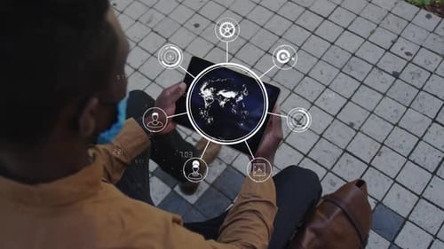 Animation of global digital interface and icons with businessman in face mask using tablet in street