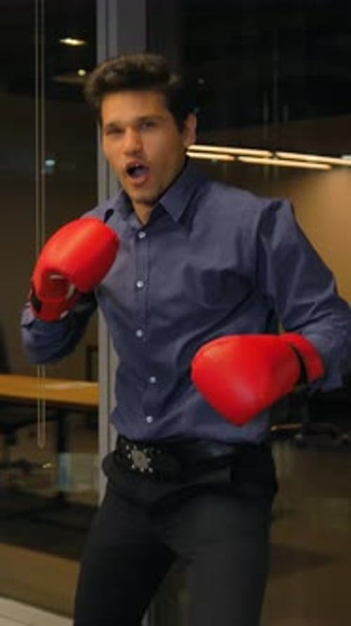 Man in Boxing Gloves Punching in Modern Office