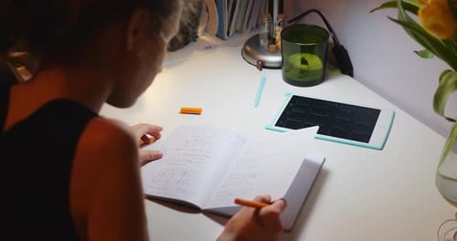 Young Adult Studying at Desk with Tablet