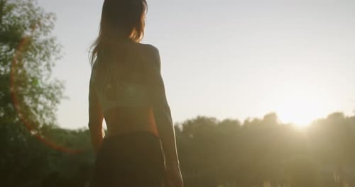 Woman Exercising with Resistance Band During Sunrise